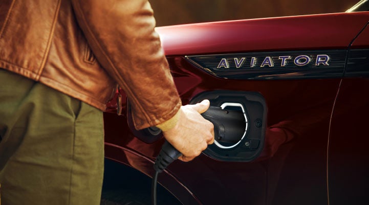 A hand is shown plugging in the charger into the charging port of a 2021 Lincoln Aviator | Thomasville Lincoln in Thomasville GA