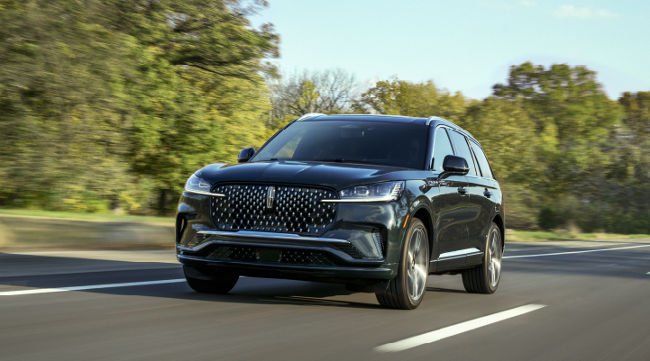 A 2025 Lincoln Black Label Aviator® SUV is being driven down a road lined with trees. | Thomasville Lincoln in Thomasville GA
