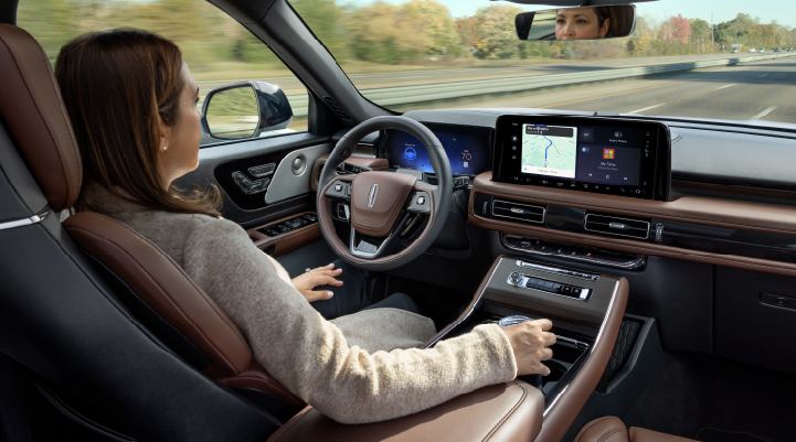 A woman is seen sitting in the driver’s seat of her 2025 Lincoln Aviator® SUV with her hands off the steering wheel. | Thomasville Lincoln in Thomasville GA
