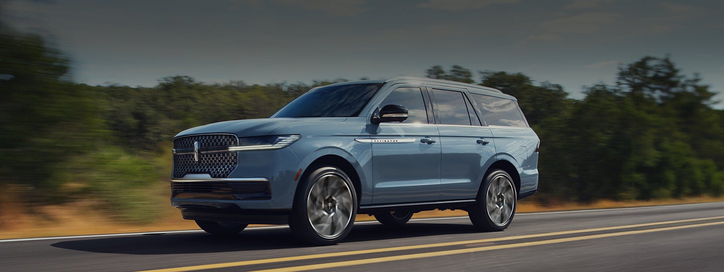 A 2026 Lincoln Navigator® SUV is being driven on a rural highway